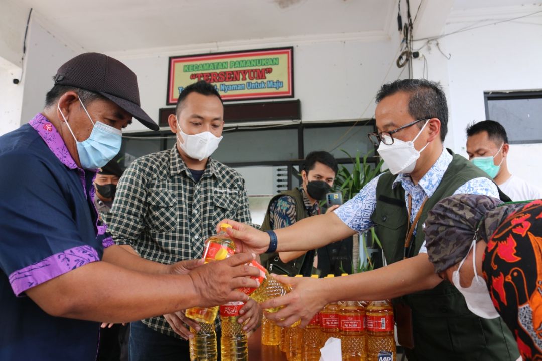 Kepala Indag Jabar Iendra Sofyan turut melayani memberikan minyak goreng kepada warga pada OP Minyak Goreng di Pamanukan 5ubang, Jumat, 18/3.