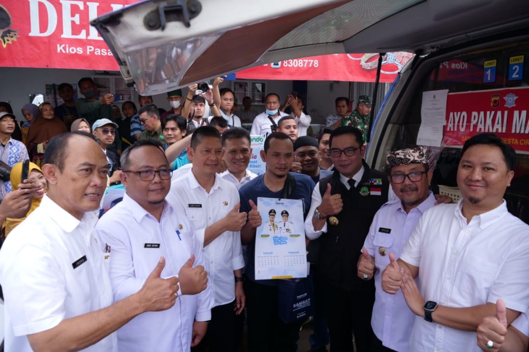 Gubernur Jabar Ridwan Kamil saat berfoto bersama dengan salah seorang wajib bayar pajak PKB di Mobil layanan Samsat Keliling Wilayah Bogor, di Pasar Pasalaran Weru Kab Cirebon, Rabu 25/1. 