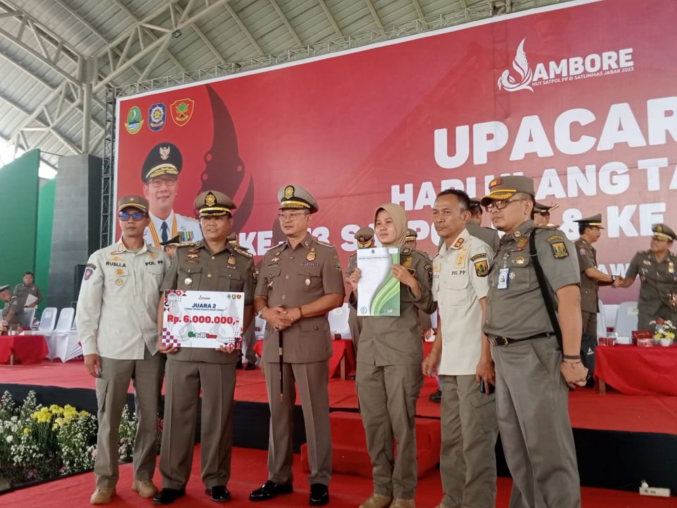 Kasatpol PP Jabar M Ade Afriandi saat menyerahkan hadiah kepada pemenang lomba  pada Peringatan HUT ke-73 Satpol PP dan Satlinmas ke-61 di Gedung Budaya Sabilulungan, Kabupaten Bandung, Jumat (10/3/2023).