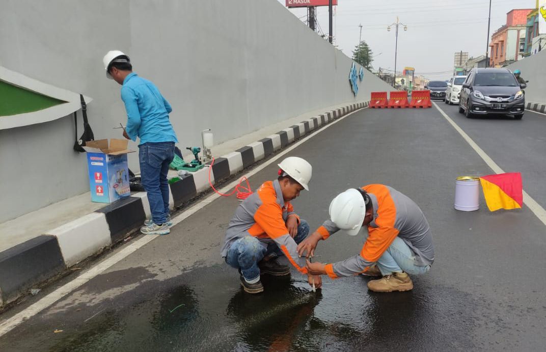 Kebocoran air di jalan Underpass Depoksedang ditangani dengan grouting semen sejak Jumat 24/3. Bawah, pengelasan gutter telah selesai.