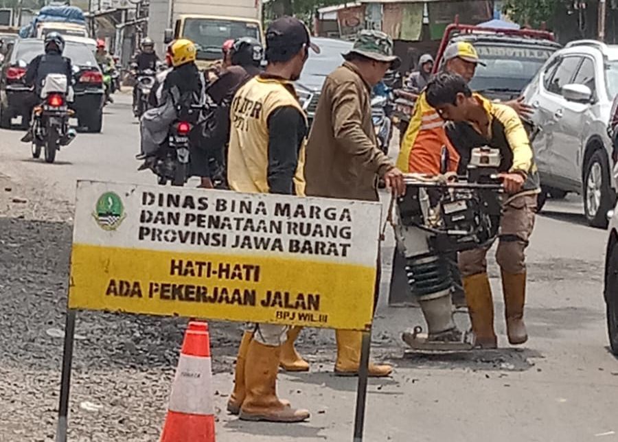 Petugas UPTD 3 Dinas BMPR Jabar saat melakukan penutupan lobang di ruas jalan Laswi Kawasan Bojongsoang Kab. Bandung, 15 Januari 2024. , 