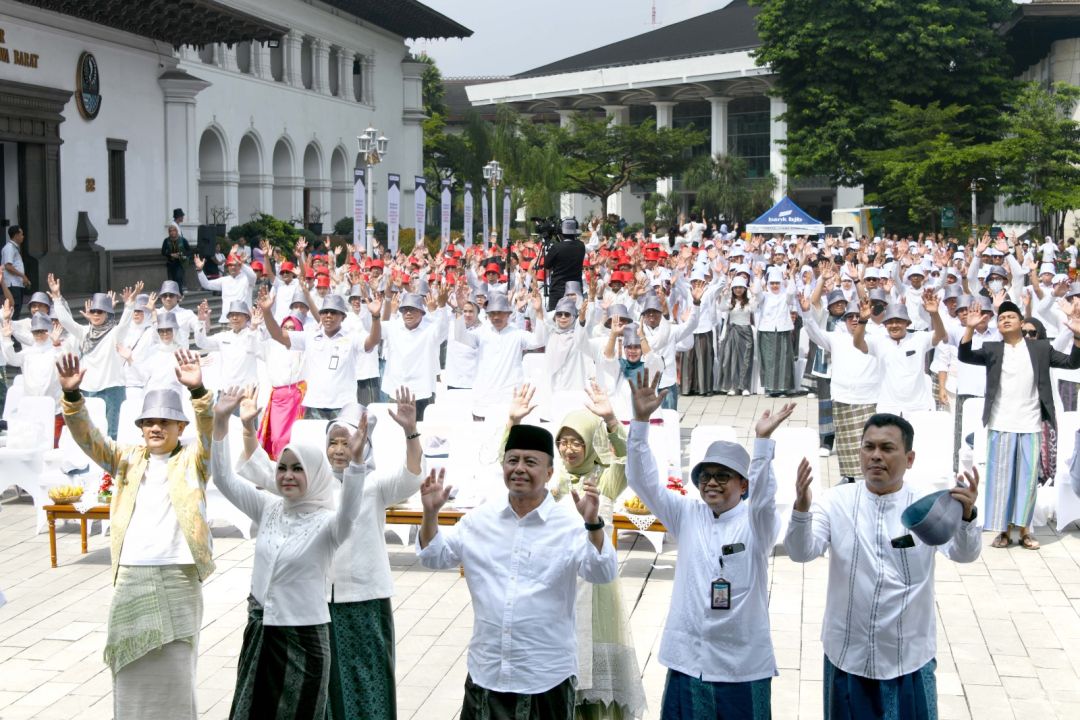  Sekda Jabar Herman Suryatman bersama puluhan ribu ASN yang mengenakan sarung tenun saat pemecahan rekor Muri dengan Ikrar Bangga Buatan Indonesia di halaman depan Gedung Sate,Kota Bandung, Jumat (22/11/2024).